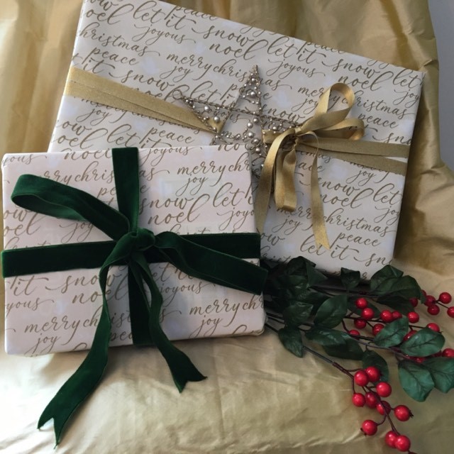 Gold and white wrapping paper is tied with green velvet and gold satin ribbon